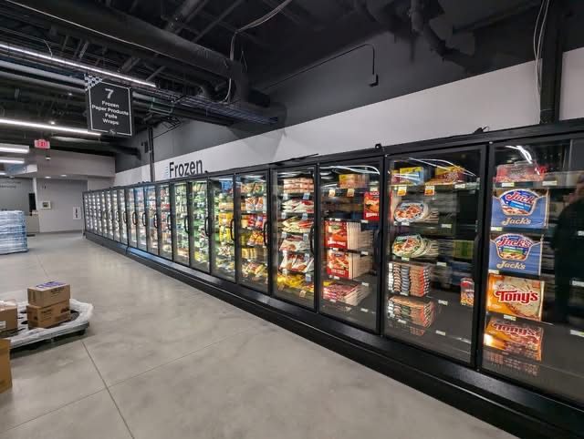 Row of glass-door refrigerated display cases in a grocery frozen aisle